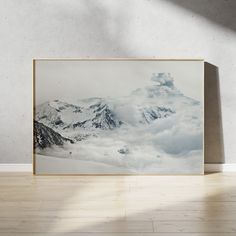 an art print on the wall above a wooden floor in front of a white wall