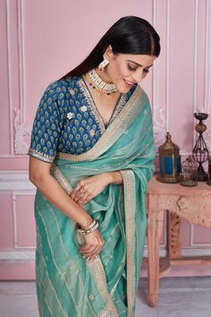 Flaunt your elegant style on festive occasions in this sea green striped embroidered organza saree. It comes with a printed and embroidered saree blouse. Disclaimer: The shown stitched blouse on the model is for display purpose only. The saree comes with a matching blouse piece and finished with fall and piko. Green Organza Blouse With Resham Embroidery, Green Organza Blouse For Festivals, Blue Zari Weaving Blouse For Eid, Blue Blouse With Zari Weaving For Eid, Embroidered Saree Blouse, Organza Sari, Tussar Silk Sarees, Indian Clothing Store, Latest Designer Sarees