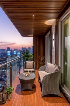 two wicker chairs sitting on top of a wooden deck