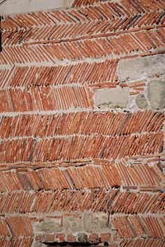 an old brick wall that has been made into a herringbone pattern