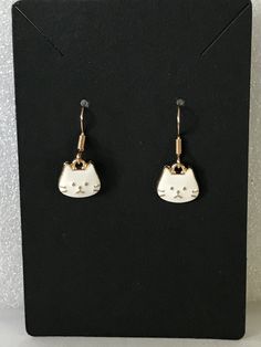 Adorable Cat Earrings! These come in white or black! Purrfect gift for cat lovers! Let us know if you have any questions please! All sales are final. Materials Plated nickel free ear wires Gold or silver Plated Enamel Charms Visit our shop to see cool stuff for Cat People and Cats! https://www.etsy.com/shop/FurballFables We are Furball Fables on YouTube, Facebook, Instagram, Threads, Tiki's Toc and Pinterest. Come hang out with us! White Cat Design Earrings For Gift, White Cat Design Earrings As A Gift, Adjustable White Cat Design Jewelry, White Cat Design Earrings As Gift, Cute White Cat Ears Jewelry, Adjustable White Jewelry With Cat Design, White Cat Design Jewelry With Cat Ears, Novelty White Cat Design Jewelry, Cute White Jewelry With Cat Design