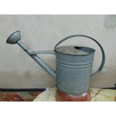 an old watering can with a metal handle