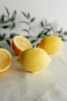 three lemons sitting on top of a white cloth