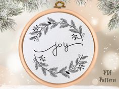 a cross stitch ornament with the word joy on it