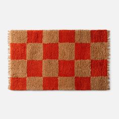 an orange and brown rug with squares on it, in the shape of a checkerboard