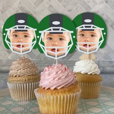 three cupcakes with football helmets on them