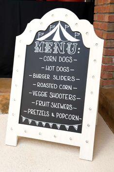 a chalkboard sign with the words menu written on it and an image of a tent in the background