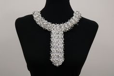 a black mannequin with a white and silver necklace on it's neck