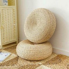 a stack of wicker cushions sitting on top of a floor next to a white cabinet