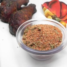 a bowl filled with spices next to some meat