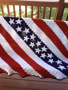 an american flag crocheted afghan on a bench