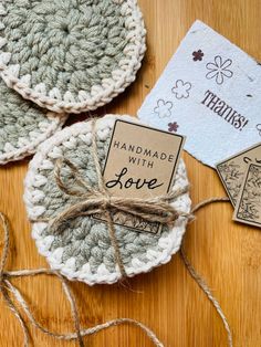 two crocheted coasters on a wooden table with twine tied around them