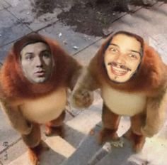 two people dressed as monkeys standing on the sidewalk