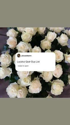 a bouquet of white roses sitting on top of a table