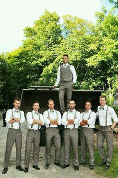 a group of men standing next to each other in front of a truck with their arms crossed