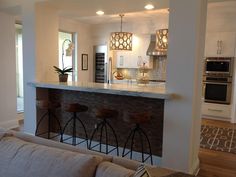 a living room filled with furniture next to a kitchen