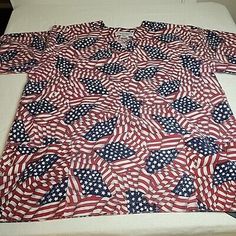 an american flag quilt is laying on top of a white tablecloth covered in red, white and blue stars