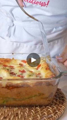 a person in an apron is adding cheese to a casserole