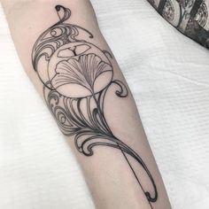 a black and white photo of a flower tattoo on the left arm with an arrow