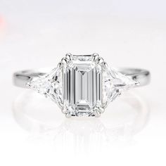 an emerald cut diamond ring with three side stones