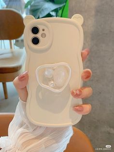 a woman holding up a phone case with an image of two hearts in the middle