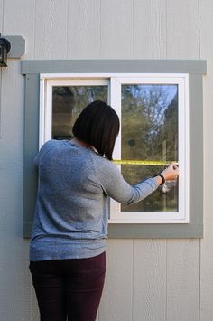 a woman is opening the window to look outside