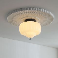 a white ceiling light hanging from the ceiling in a room with no one around it