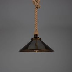 an industrial style light hanging from a rope