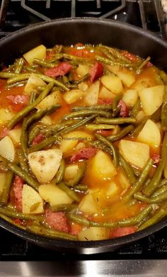 potatoes and green beans in a pan on the stove