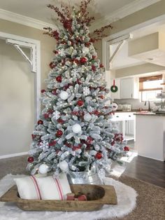 a white christmas tree with red and silver ornaments