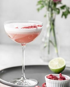 a drink in a coupe glass with raspberry sprinkles on the rim