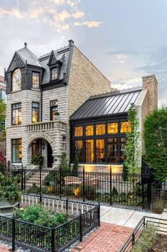 a large brick house with many windows and iron fenced in areas around the front yard