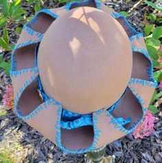 Looking for a dimensional hat?    Something a bit different that everyone else? This is a one of a kind hand stretched over a hat block wool carmel hat with blue hand stitching around the brim. Hat band is blue and white ribbon with a round floral copper pendant.  The copper pendant is embossed with texture. Hand painted flowers in matching blue and white on the underside of the brim with burned embellishments in the middle of each flower.   SIZE:  Adult Medium or 21-23 1/2inches. To see how to measure your fit please check out the video. NO EXCHANGES OR RETURNS IN THE USA. Hat Blocks, Blue Hand, Painted Flowers, Hand Painted Flowers, Copper Pendant, White Ribbon, Copper Pendants, Hat Band, Brim Hat