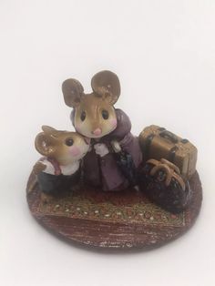 a figurine of two mice with luggage