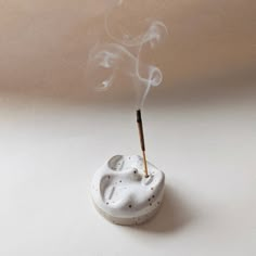 Ceramic face shape round incense stick holder with a burning incense stick in its mouth. Incense Holder Ceramics, Airdry Clay Incense Holders, Incesence Holder Clay, Diy Insence Holder, Ceramic Insence Holder, Face Incense Holder, Handmade Ceramics Ideas, Pottery Incense Holder, Moon Incense Holder