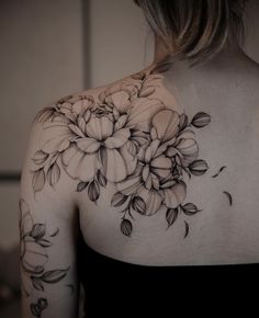 the back of a woman's shoulder with flowers on it