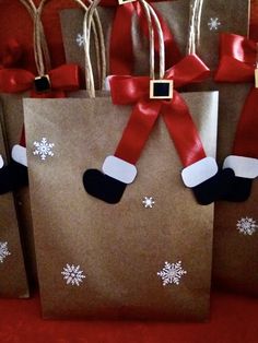 three brown bags with red and white snowflakes on them, one has a santa's stocking