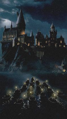 the hogwarts castle is lit up at night in front of a dark cloudy sky