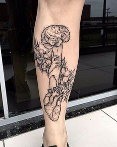 a woman's leg with a tattoo on it that has flowers growing out of it