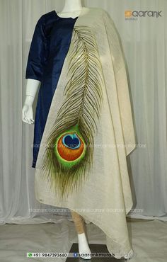 a mannequin wearing a white and blue dress with a peacock feather on it