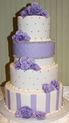 a three tiered cake with purple flowers on it