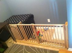 a baby crib with toys in it next to a blue wall and rug on the floor