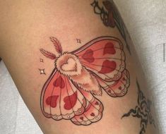 a close up of a tattoo with a butterfly on it's thigh and heart in the middle