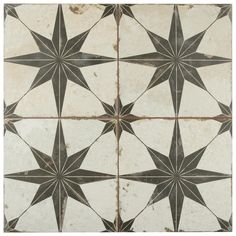 an old black and white tiled floor with star designs