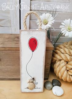 a wooden sign with a balloon attached to it