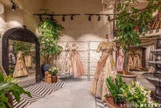 a room filled with mannequins and potted plants