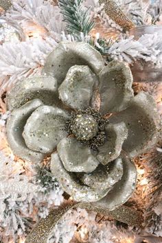 a white christmas tree with silver and gold decorations