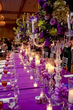 a long table with candles and flowers on it is set up for a formal function