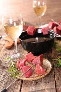 watermelon skewers on a plate next to a glass of white wine