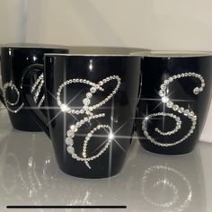 three black coffee mugs decorated with swaroons and the number 35 on them